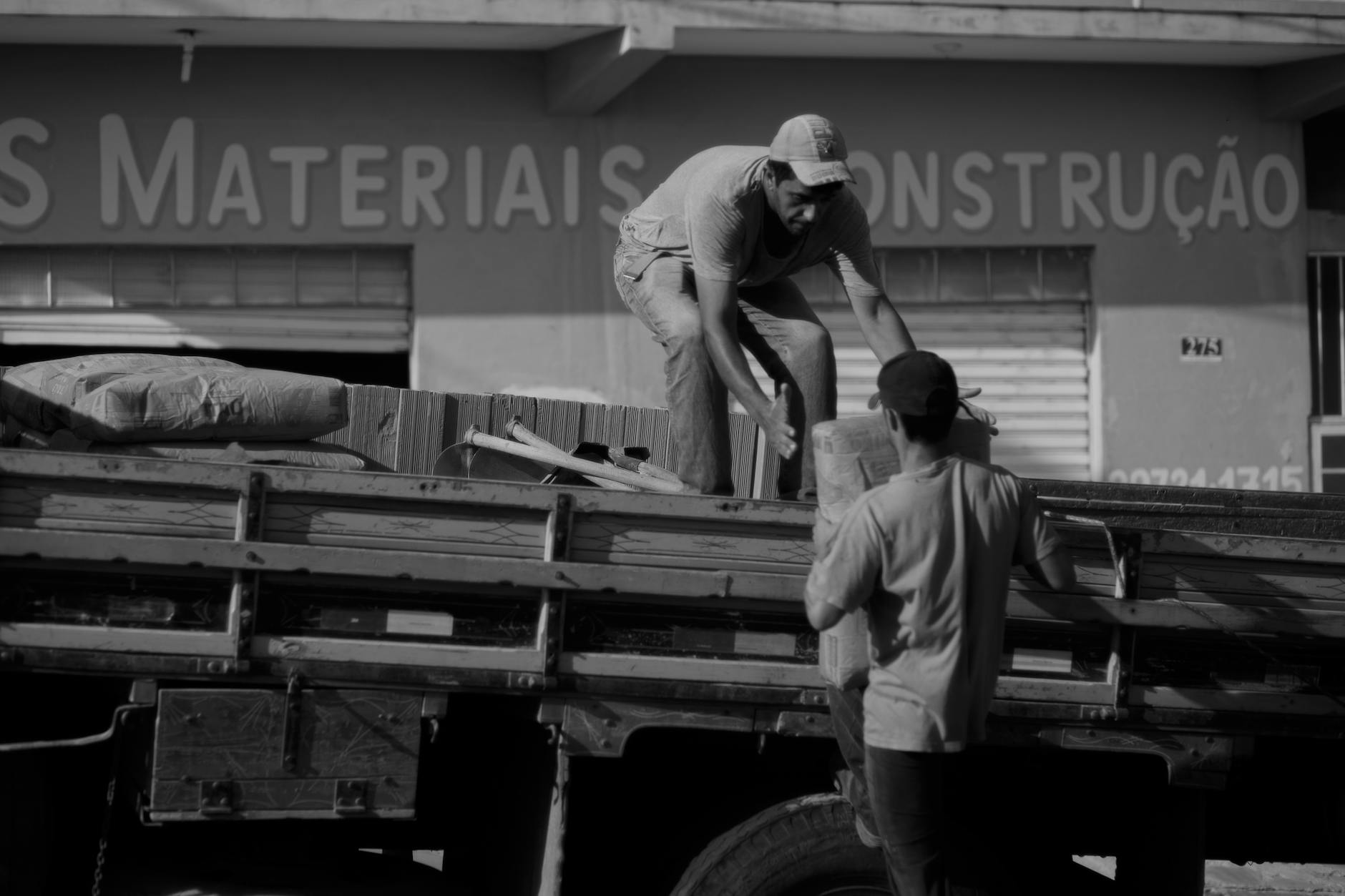 men loading bags on truck
